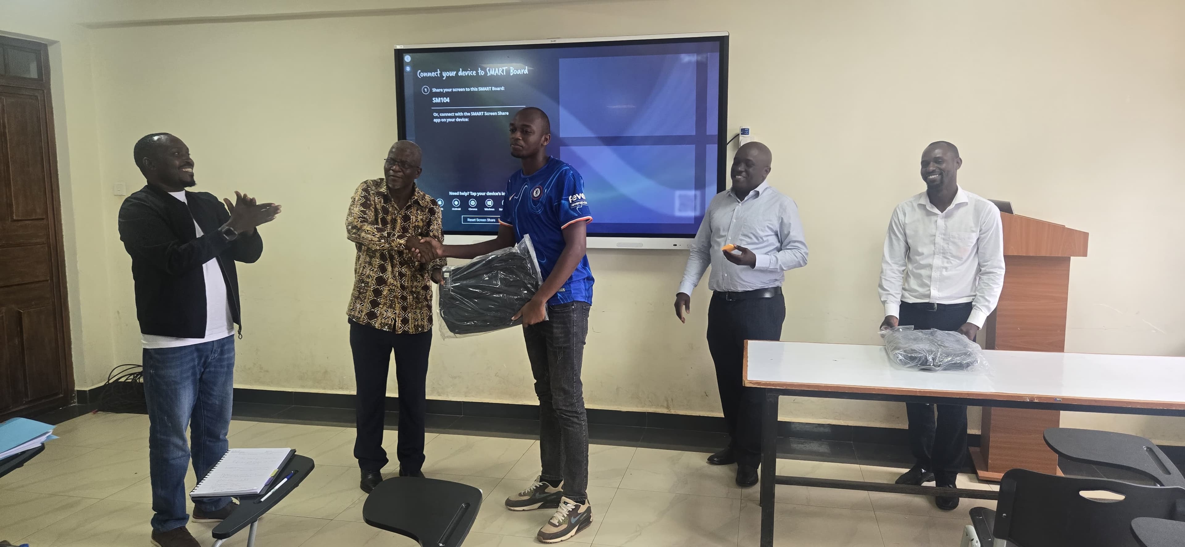Animator Larson Masawe receiving recognition through a gift for their outstanding contributions.